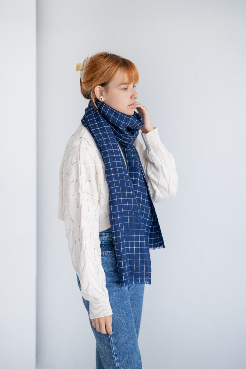 Women wearing a blue checkered linen scarf against a plain background

