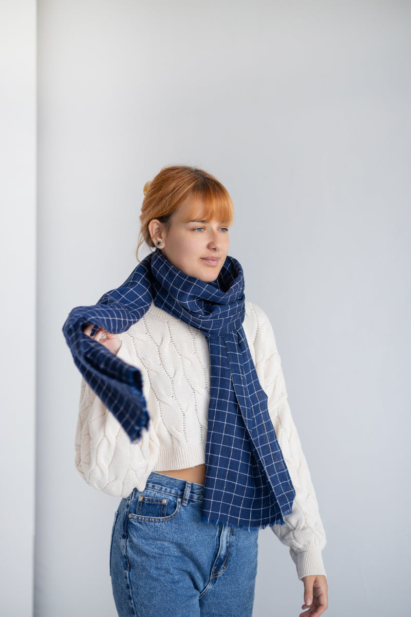 Women wearing a blue checkered linen scarf against a plain background
